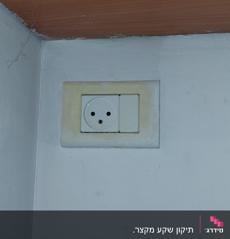 שקע חשמל בקיר לבן עם מתג